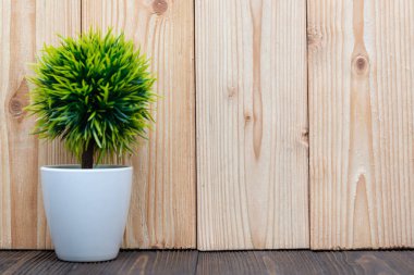 Küçük dekoratif ağaç ve çiçek buketi kopya alanı ile ahşap masa üzerinde beyaz cam aranjman. arka plan.