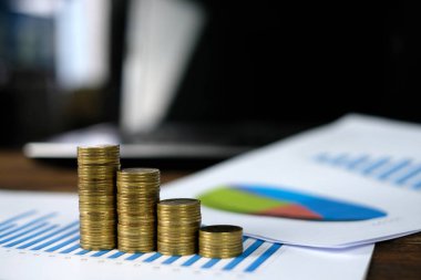 Beyaz kağıt çalışma tablosu, iş planlama vizyonu ve Finans analiz kavramı fikir üzerinde adım para yığınları dizüstü dizüstü bilgisayar ve mali grafik ile /. ve kopya alanı için metin ekleme.