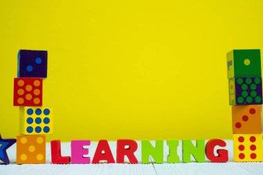 Öğrenme metin alfabesi ve oyuncak kare bulmaca sarı duvar arka plan ile tabloda blok