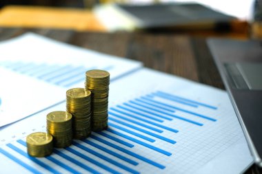 Beyaz kağıt çalışma tablosu, iş planlama vizyonu ve Finans analiz kavramı fikir üzerinde adım para yığınları dizüstü dizüstü bilgisayar ve mali grafik ile /. ve kopya alanı için metin ekleme.