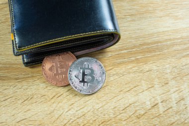 Bitcoin dijital para yerine gerçek para, bit-sikke ile deri cüzdan veya çantanızda ahşap çalışma masa, sanal cryptocurrency para iş kavramı fikri üzerinde.
