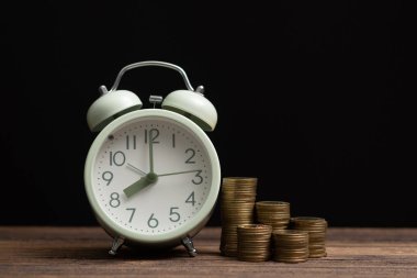 Çalar saat ve karanlık bir odada, tasarruf para kavramı, bankacılık ve iş kavramı fikri çalışma tablo para yığınları.
