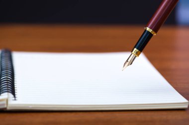 Dolma kalem veya tükenmez kalem defter kağıt üzerinde kopya alanı, office Danışma konsept fikir ile ahşap çalışma masa ile kapatın. sığ odak.