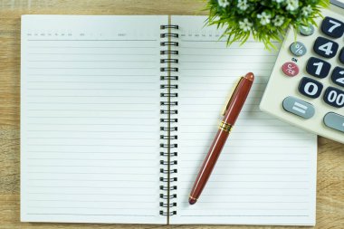 Dolma kalem veya tükenmez kalem defter kağıt ve ahşap çalışma masa kopya alanı, office Danışma konsept fikir ile hesap makinesi ile. Üstten Görünüm.