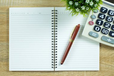 Dolma kalem veya tükenmez kalem defter kağıt ve ahşap çalışma masa kopya alanı, office Danışma konsept fikir ile hesap makinesi ile. Üstten Görünüm.