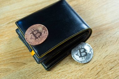 Bitcoin dijital para yerine gerçek para, bit-sikke ile deri cüzdan veya çantanızda ahşap çalışma masa, sanal cryptocurrency para iş kavramı fikri üzerinde.