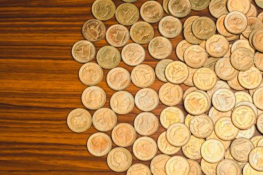 Ahşap çalışma masa, iş ve finans kavramı fikri üzerine sikke yığını.