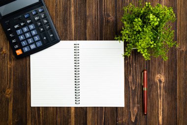 Dolma kalem veya tükenmez kalem defter kağıt ve ahşap çalışma masa kopya alanı, office Danışma konsept fikir ile hesap makinesi ile. Üstten Görünüm.
