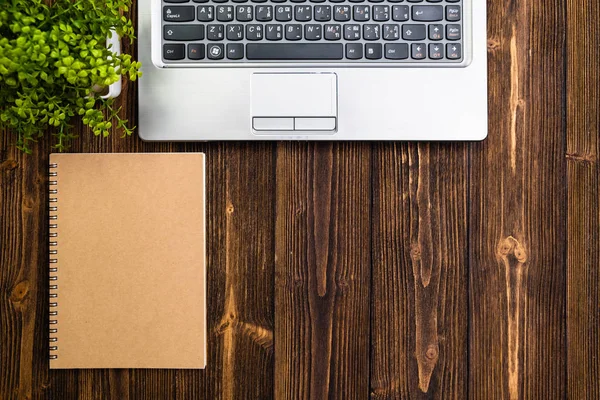 Office supplies or office work essential tools or items on wooden desk in workplace, laptop computer notebook calculator and alarm clock, top view with copy space for add text and message.