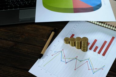 Beyaz kağıt çalışma tablosu, iş planlama vizyonu ve Finans analiz kavramı fikir üzerinde adım para yığınları dizüstü dizüstü bilgisayar ve mali grafik ile /. ve kopya alanı için metin ekleme.