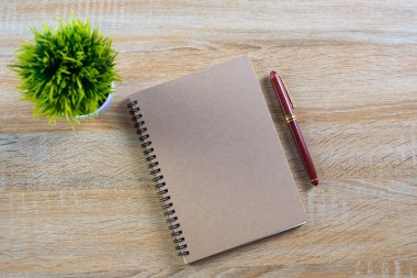Dolma kalem veya tükenmez kalem defter kağıt ve küçük dekorasyon ağaç ahşap çalışma masa kopya alanı, office Danışma konsept fikir ile üzerinde beyaz cam aranjman. Üstten Görünüm.