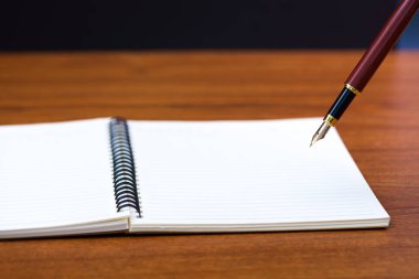 Dolma kalem veya tükenmez kalem defter kağıt üzerinde kopya alanı, office Danışma konsept fikir ile ahşap çalışma masa ile kapatın. sığ odak.