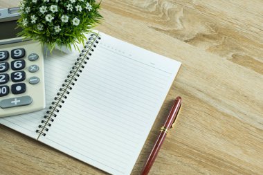 Dolma kalem veya tükenmez kalem defter kağıt ve ahşap çalışma masa kopya alanı, office Danışma konsept fikir ile hesap makinesi ile. Üstten Görünüm.