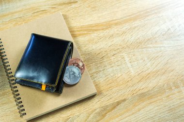 Bitcoin dijital para yerine gerçek para, bit-sikke ile deri cüzdan veya çantanızda ahşap çalışma masa, sanal cryptocurrency para iş kavramı fikri üzerinde.