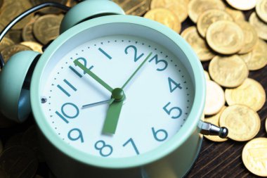 Çalar saat ve karanlık bir odada, tasarruf para kavramı, bankacılık ve iş kavramı fikri çalışma tablo para yığınları.