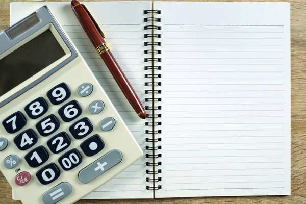 Dolma kalem veya tükenmez kalem defter kağıt ve ahşap çalışma masa kopya alanı, office Danışma konsept fikir ile hesap makinesi ile. Üstten Görünüm.