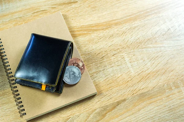 Bitcoin dijital para yerine gerçek para, bit-sikke ile deri cüzdan veya çantanızda ahşap çalışma masa, sanal cryptocurrency para iş kavramı fikri üzerinde.