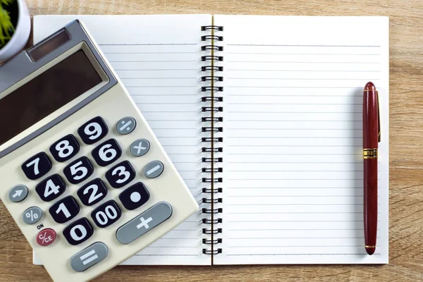 Dolma kalem veya tükenmez kalem defter kağıt ve ahşap çalışma masa kopya alanı, office Danışma konsept fikir ile hesap makinesi ile. Üstten Görünüm.