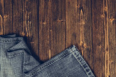 Kaba koyu ahşap masa arka plan, kopya alanı, eski moda stil kavramı ile üstten görünüm üzerinde yıpranmış kot pantolon ya da kot denim koleksiyonu.
