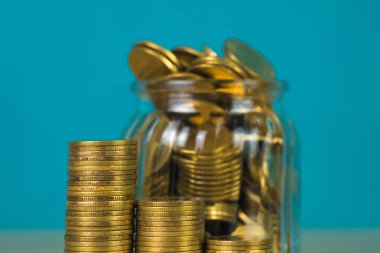 Madeni para yığınları ve altın sikke para cam kavanoz tablo kaydetme gelecekteki bankacılık finans için yeşil arka plana sahip konsept fikir.