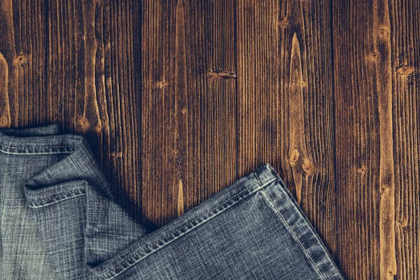 Colección Vaqueros Deshilachados Vaqueros Azules Sobre Fondo Mesa Madera Oscura — Foto de Stock