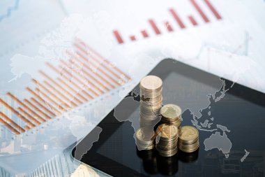 Sikke yığını ve tablet şehir arka plan ve Dünya Haritası, mali grafik, Dünya Haritası ve küresel ağ iş kavramı fikri, Nasa tarafından öğe ile çift pozlama.