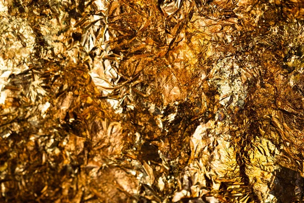 Shiny yellow gold leaf or scraps of gold foil background texture, surface from Back of Buddha image.