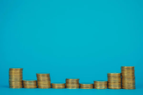 Columns of coins, piles of coins on blue background, business and financial concept idea.