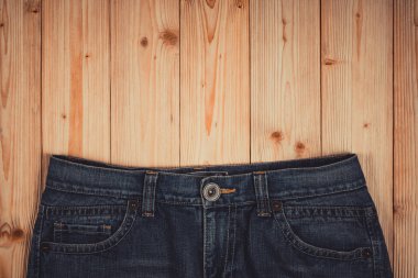 Kot pantolon ya da kot denim koleksiyonu kopya alanı, eski moda stil kavramı ile kaba ahşap masa arka plan üzerinde yıpranmış.