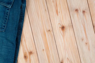 Kot pantolon ya da kot denim koleksiyonu kopya alanı, eski moda stil kavramı ile kaba ahşap masa arka plan üzerinde yıpranmış.