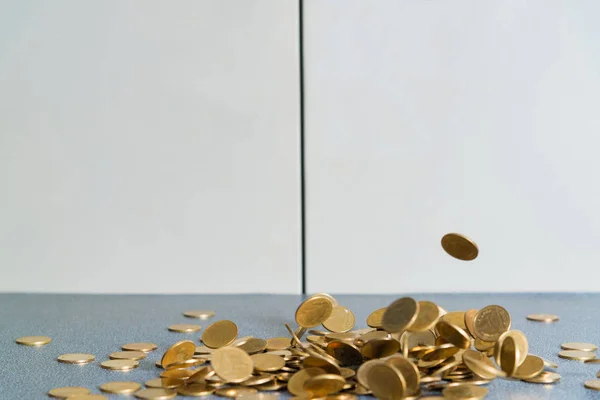 Falling gold coins money on office table with document cabinet background, business money and finance concept idea.