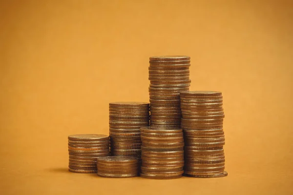 Columns of coins, piles of coins on brown background, business and financial concept idea.