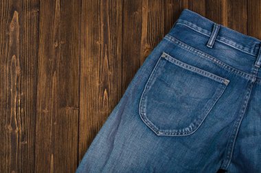 Kaba koyu ahşap masa arka plan, kopya alanı, eski moda stil kavramı ile üstten görünüm üzerinde yıpranmış kot pantolon ya da kot denim koleksiyonu.