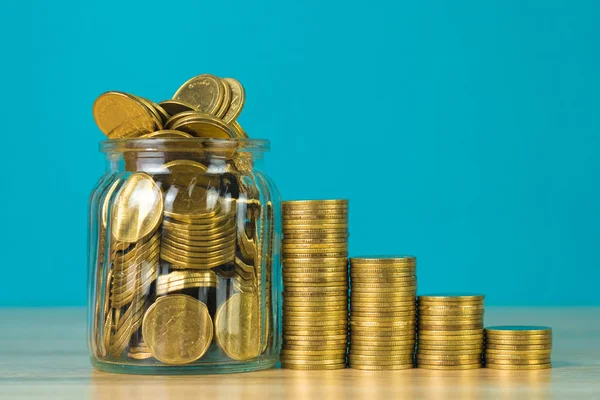 Madeni para yığınları ve altın sikke para cam kavanoz tablo kaydetme gelecekteki bankacılık finans için yeşil arka plana sahip konsept fikir.