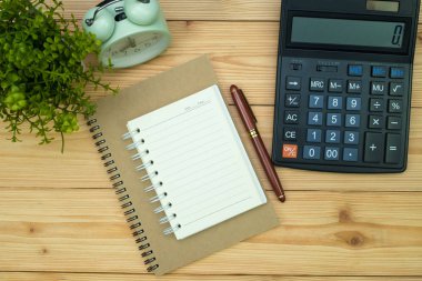 Ofis, banka donatımı veya office temel araçları öğelerini işyerinde, kalem defter ve hesap makinesi ile ve çalar saat ile kopya alanı, ahşap masa görünümü top