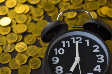 Çalar saat ve çalışma tablosu, tasarruf para kavramı, bankacılık ve iş kavramı fikri üzerinde para yığınları.