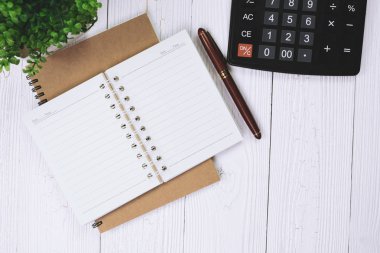 Dolma kalem veya tükenmez kalem defter kağıt ve ahşap çalışma masa kopya alanı, office Danışma konsept fikir ile hesap makinesi ile. Üstten Görünüm.