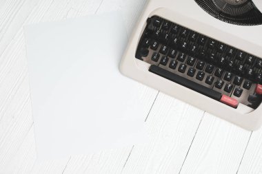 Kopya alanı için beyaz tahta masada boş kağıt levha ile Retro daktilo eklemek metin ya da kelime reklam.