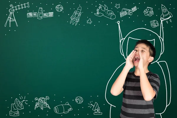 Asian kid with his imagination about science and space adventure, hand drawn on the green chalkboard, education back to school and discovery concept idea.