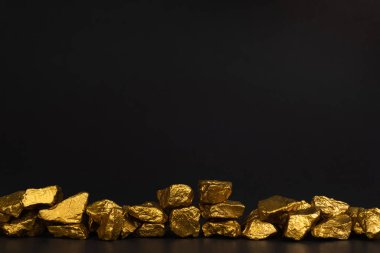 Altın nuggets veya siyah arka plan, kıymetli taş veya yumru altın taş, mali ve iş kavramı fikri altın cevheri yığını.