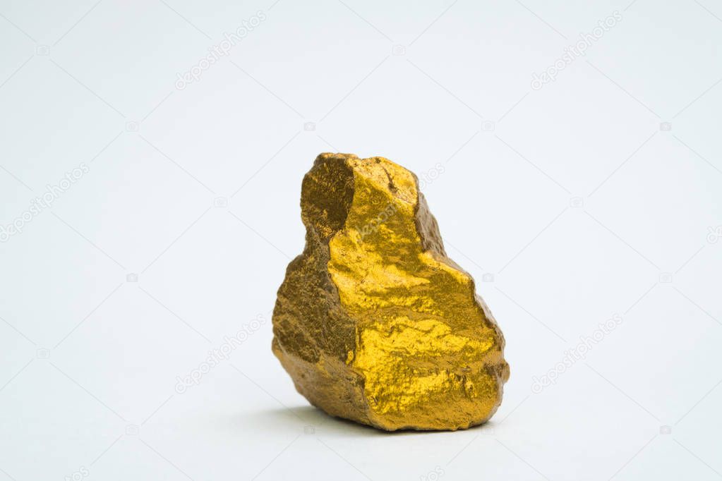 Closeup of gold nugget or gold ore on white background, precious stone or lump of golden stone, financial and business concept idea.