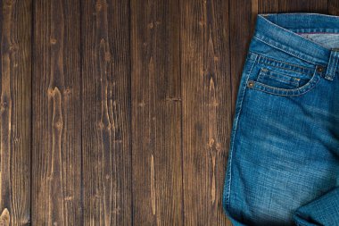 Kaba koyu ahşap masa arka plan, kopya alanı, eski moda stil kavramı ile üstten görünüm üzerinde yıpranmış kot pantolon ya da kot denim koleksiyonu.
