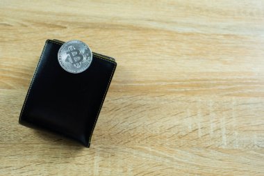 Bitcoin dijital para yerine gerçek para, bit-sikke ile deri cüzdan veya çantanızda ahşap çalışma masa, sanal cryptocurrency para iş kavramı fikri üzerinde.