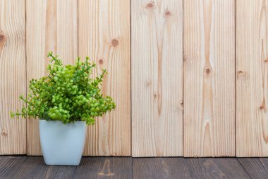 Küçük dekoratif ağaç ve çiçek buketi kopya alanı ile ahşap masa üzerinde beyaz cam aranjman. arka plan.