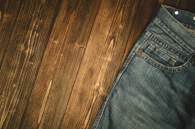 Kaba koyu ahşap masa arka plan, kopya alanı, eski moda stil kavramı ile üstten görünüm üzerinde yıpranmış kot pantolon ya da kot denim koleksiyonu.