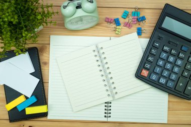 Ofis, banka donatımı veya office temel araçları öğelerini işyerinde, kalem defter ve hesap makinesi ile ve çalar saat ile kopya alanı, ahşap masa görünümü top