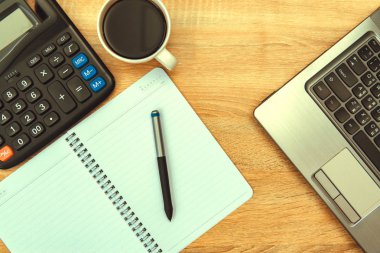 Dizüstü bilgisayar ya da defter, hesap makinesi ve kahve çalışma tablosu veya Danışma, çalışma alanı kopyasını alan içeren görünüm üst. Vintage sesi. Vintage sesi.