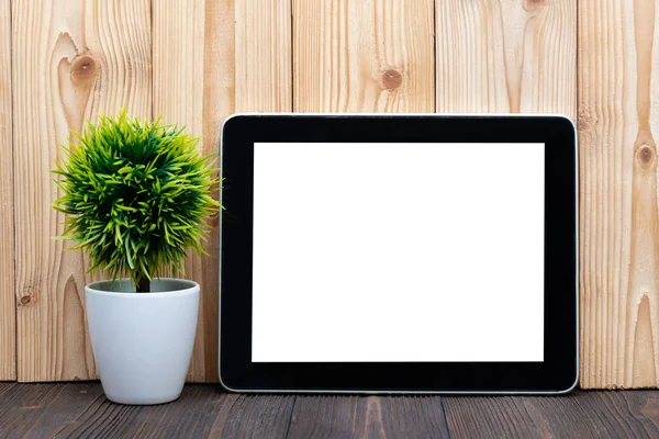 Boş tablet bilgisayar ve küçük ağaç veya çiçek buketi kopya alanı için ahşap zemin üzerine beyaz vazoda metin ekleyin.