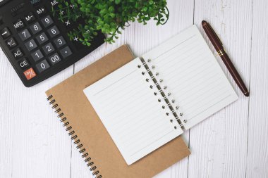 Dolma kalem veya tükenmez kalem defter kağıt ve ahşap çalışma masa kopya alanı, office Danışma konsept fikir ile hesap makinesi ile. Üstten Görünüm.