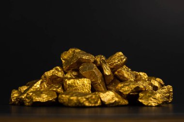 Altın nuggets veya siyah arka plan, kıymetli taş veya yumru altın taş, mali ve iş kavramı fikri altın cevheri yığını.